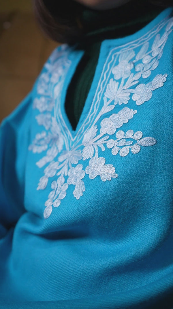 Child model wearing a designer Kashmiri pheran, featuring traditional embroidery and warm fabric for festive and cultural occasions